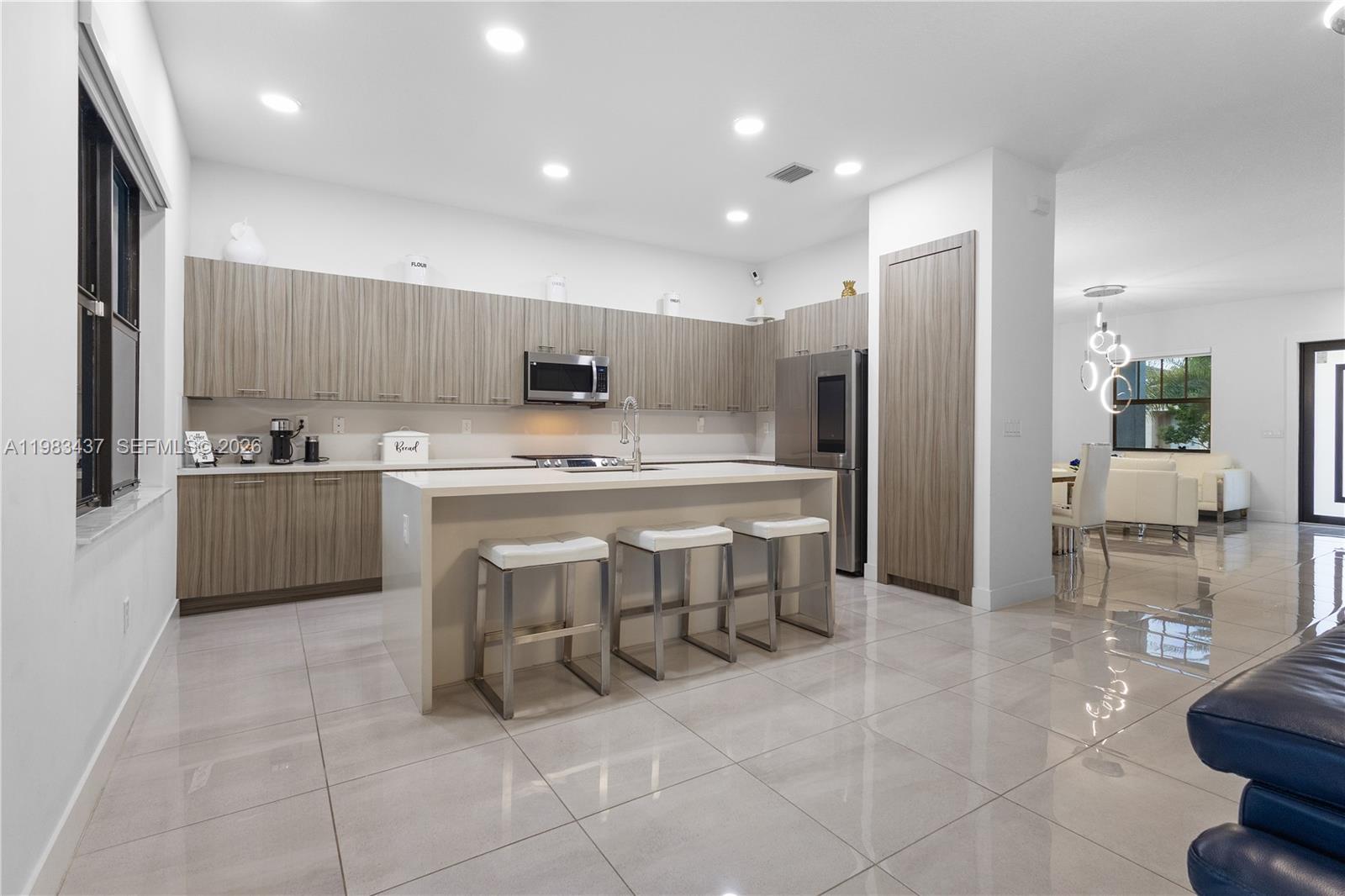 4335 Southwest 174th Avenue Miramar, FL 33029 - Photo 13 of 58 a kitchen with a sink a refrigerator and chairs