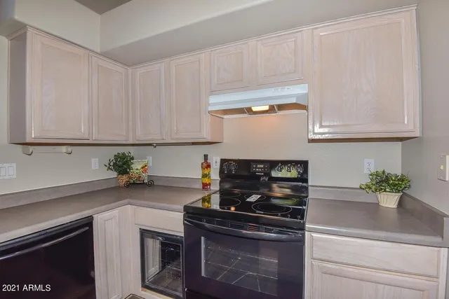 a kitchen with stainless steel appliances white cabinets and a stove top oven