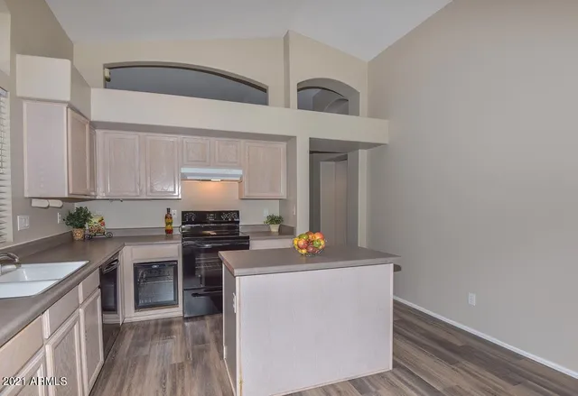 a kitchen with stainless steel appliances a stove a sink and white cabinets