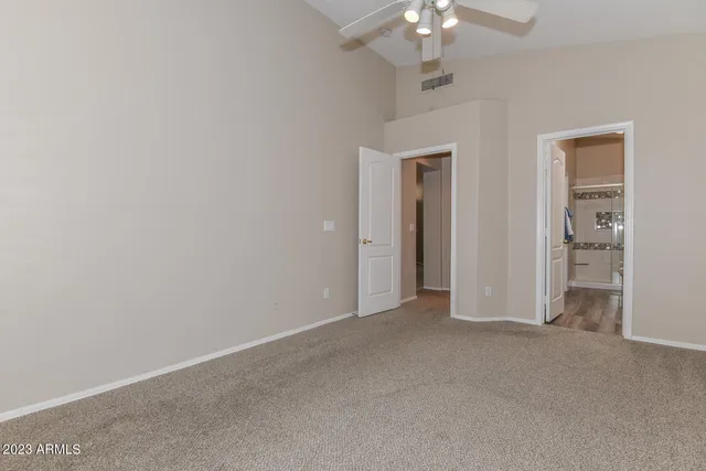 an empty room with chandelier fan