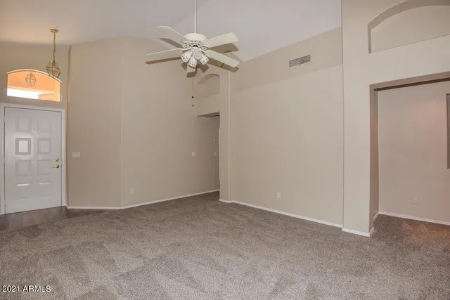 an empty room with windows and fan