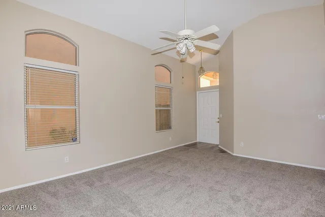 an empty room with windows and fan