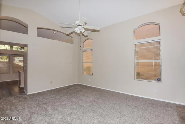 an empty room with windows and fan