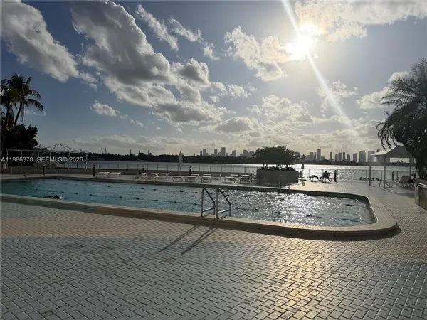 a view of swimming pool with outdoor seating and kitchen in the background