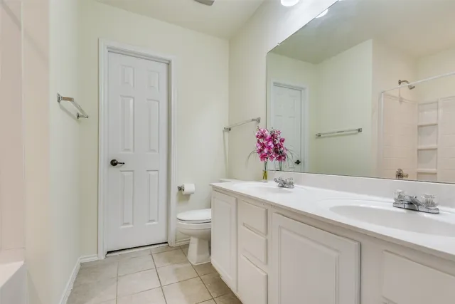 a bathroom with a granite countertop sink a toilet and shower
