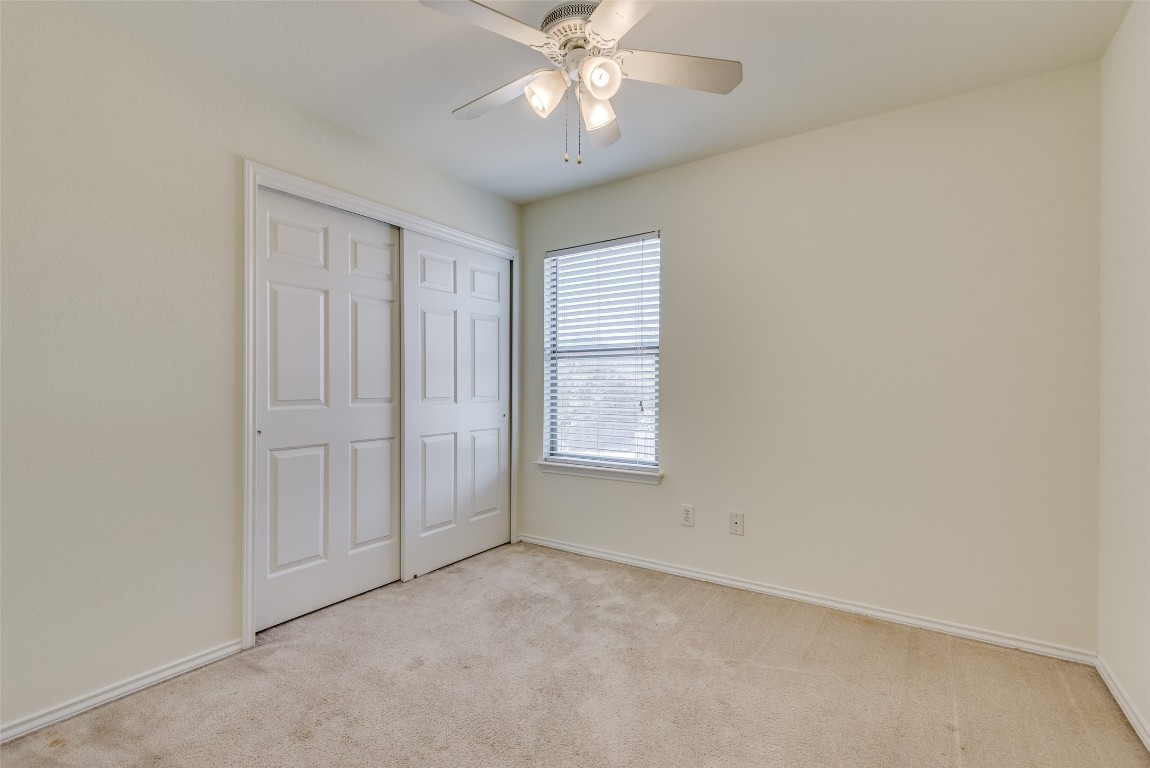 5701 Viewpoint Drive Austin, TX 78744 - Photo 19 of 25 an empty room with chandelier fan and windows