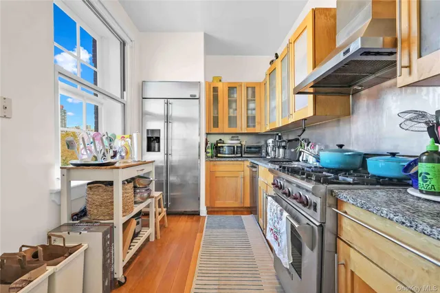 a kitchen with stainless steel appliances granite countertop a stove a sink and a refrigerator