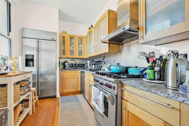 a kitchen with stainless steel appliances granite countertop a stove a sink and a refrigerator