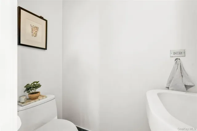 a white toilet sitting next to a white tub