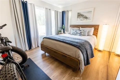 a bedroom with a bed and wooden floor