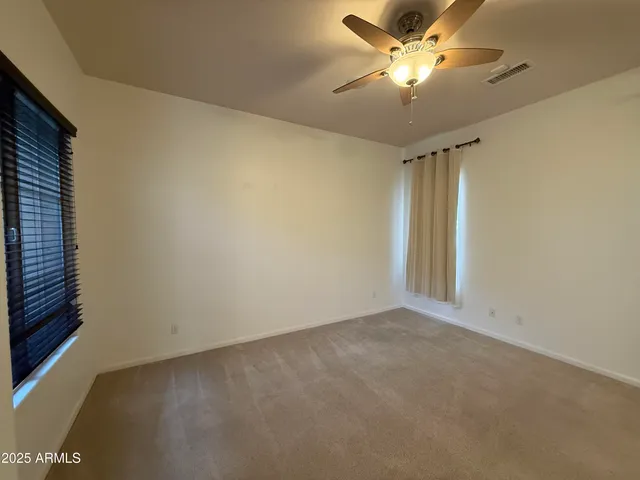 an empty room with a window and a ceiling fan