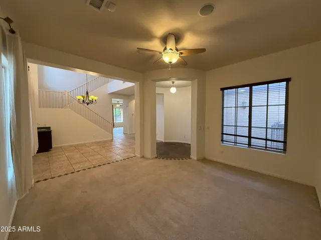an empty room with closet and a chandelier fan