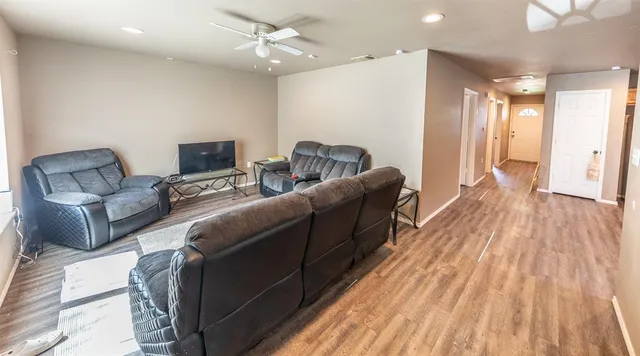 a living room with furniture and a wooden floor