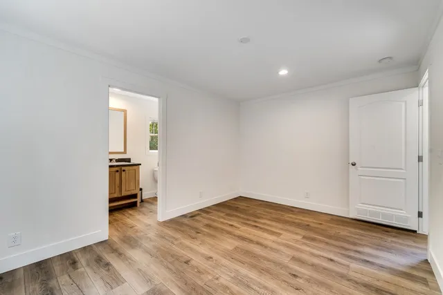 a view of a room with wooden floor and a bathroom