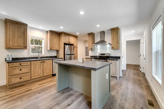 a kitchen with granite countertop a sink cabinets and wooden floor
