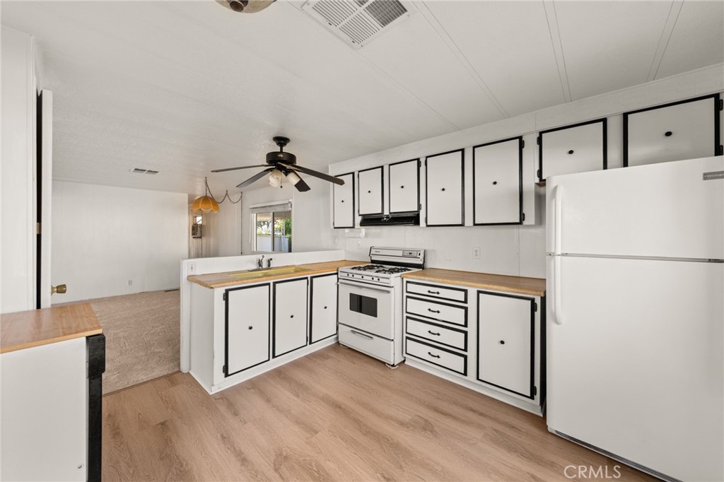 1255 Amethyst Street, Unit 32 Mentone, CA 92359 - Photo 6 of 32 a kitchen with white cabinets and white appliances