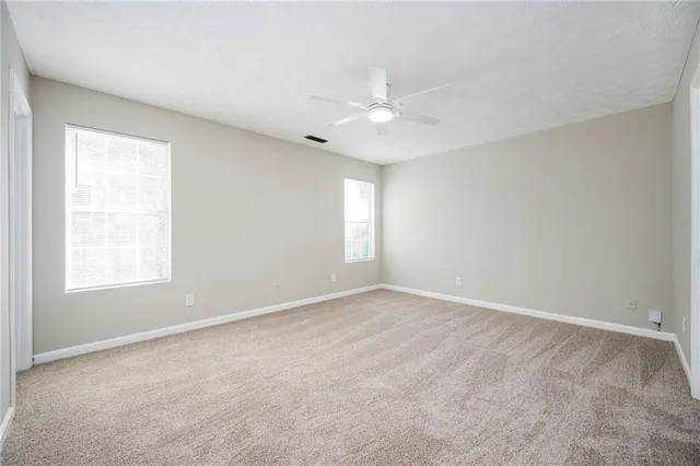 an empty room with a window and a fan