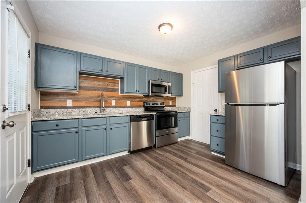 3375 River Run Trail Decatur, GA 30034 - Photo 6 of 27 a kitchen with granite countertop stainless steel appliances and wooden cabinets