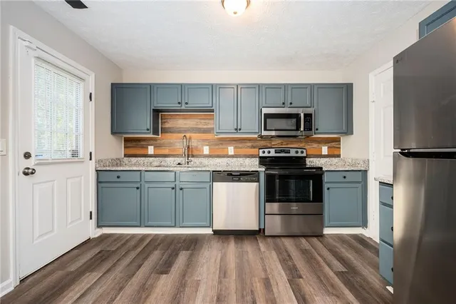 a kitchen with granite countertop a refrigerator stove and microwave