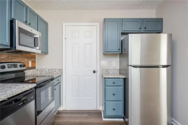 a kitchen with stainless steel appliances granite countertop a refrigerator and a stove