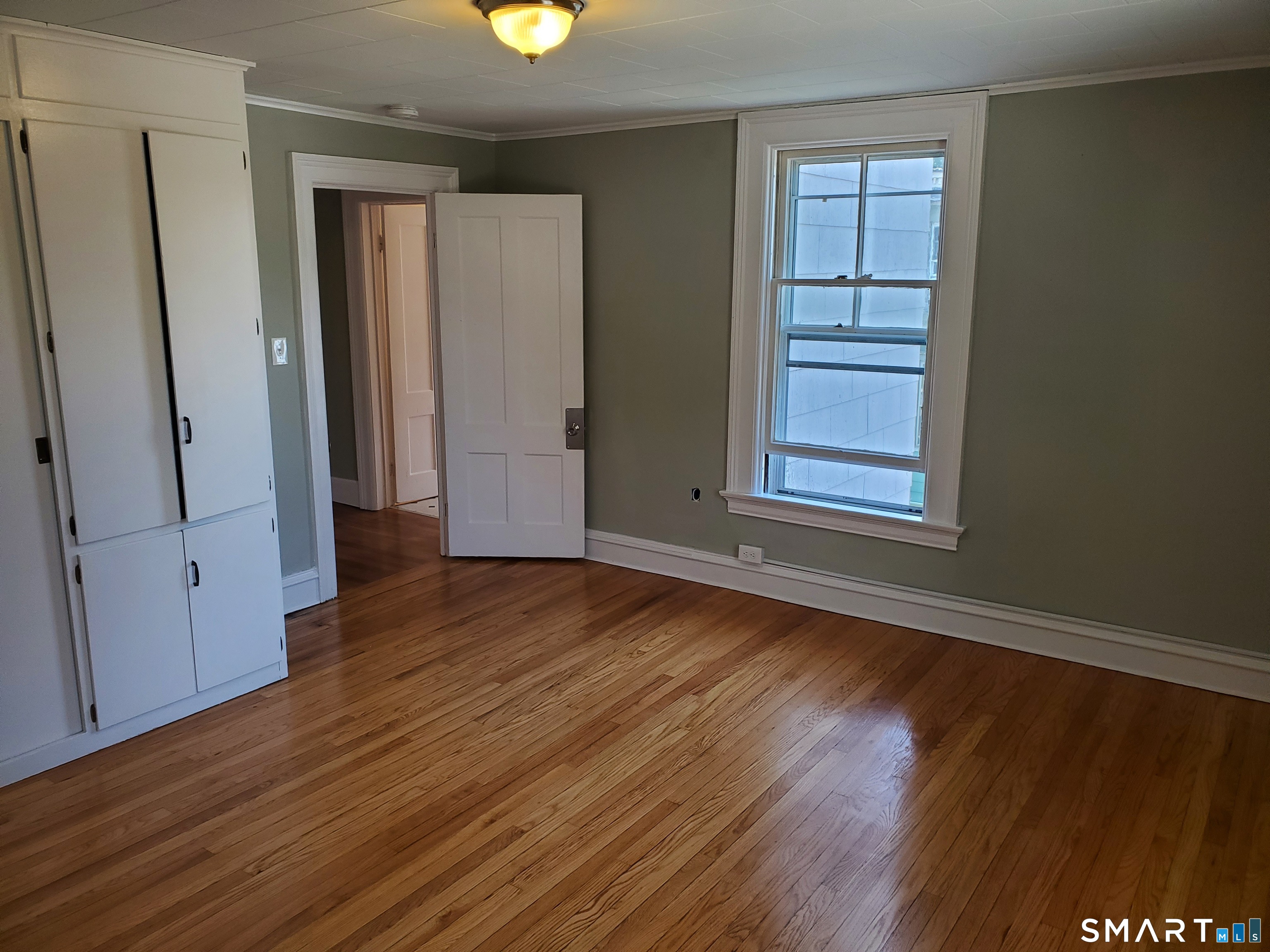 31 Bellevue Street Windham, CT 06226 - Photo 11 of 16 an empty room with wooden floor and windows