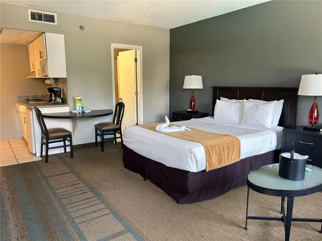 a bedroom with a bed a table and chair