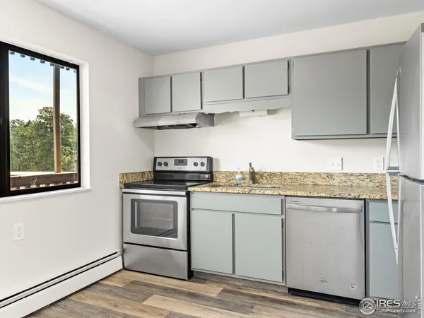 a kitchen with a refrigerator and a stove top oven