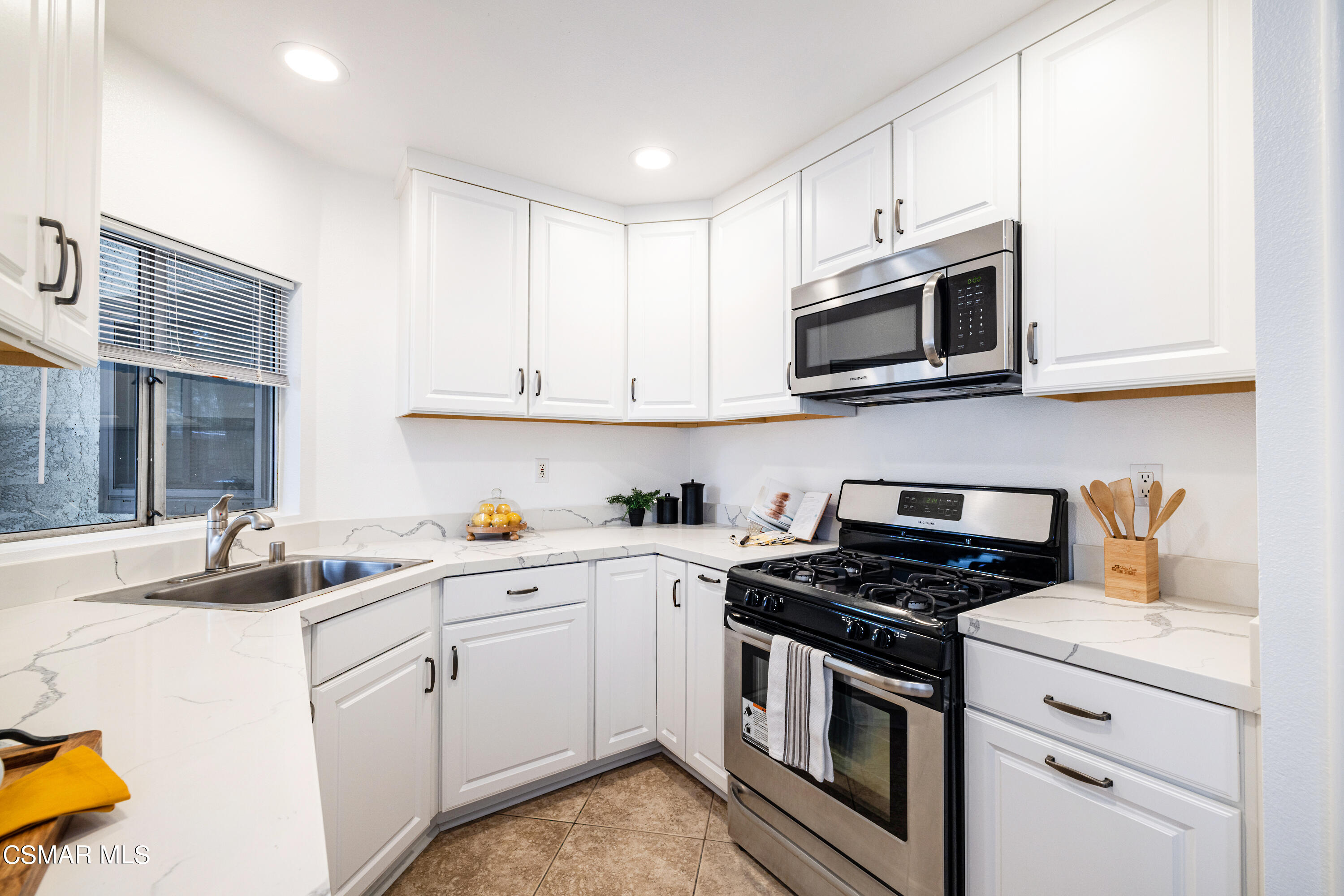 1736 Sinaloa Road, Unit 313 Simi Valley, CA 93065 - Photo 6 of 27 a kitchen with cabinets stainless steel appliances and a sink