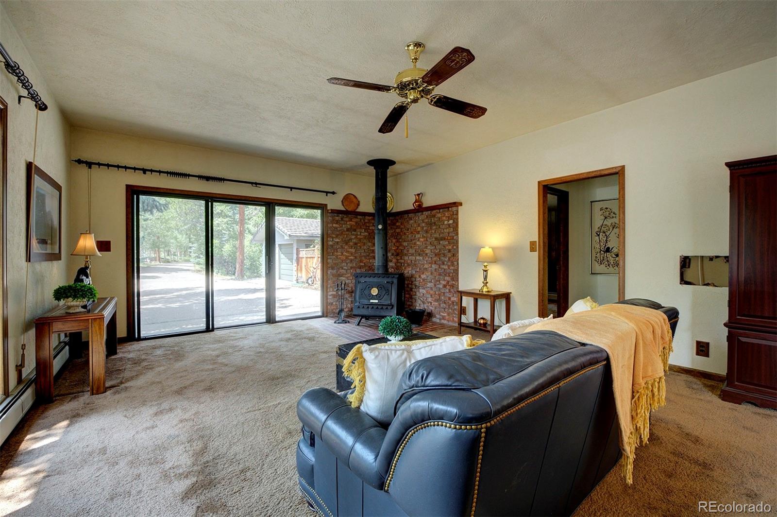 11655 Ranch Elsie Road Golden, CO 80403 - Photo 27 of 36 a living room with furniture a ceiling fan a flat screen tv and a large window