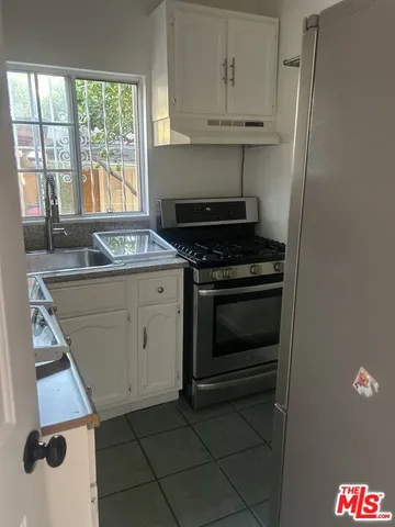a stove top oven sitting inside of a kitchen