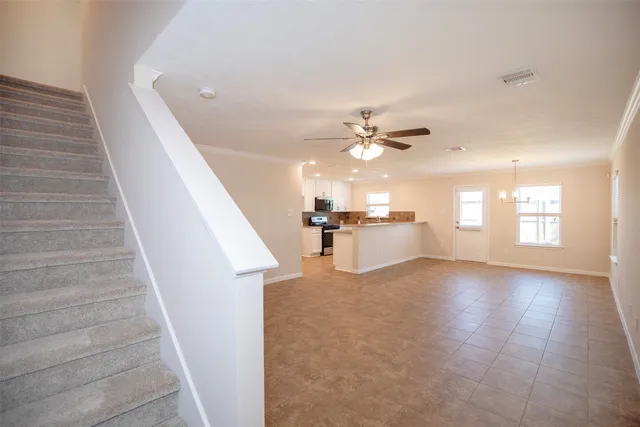 a view of a livingroom with wooden floor and staircase