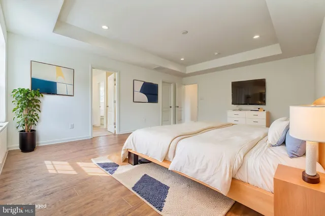 a spacious bedroom with a bed and a potted plant