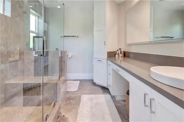 a bathroom with a granite countertop sink a toilet and shower