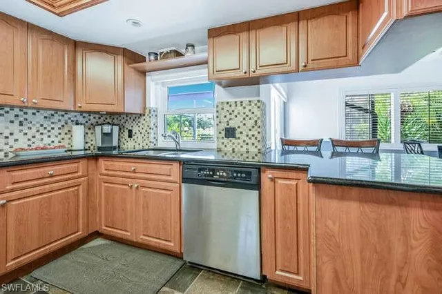a kitchen with stainless steel appliances granite countertop a sink stove and cabinets