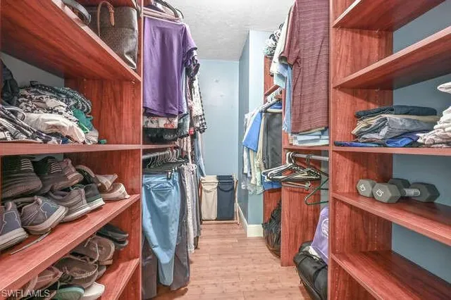 a view of walk in closet with clothes and shoes