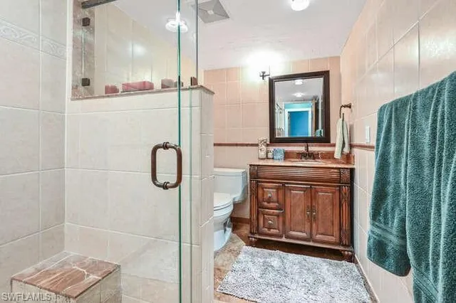 a bathroom with a granite countertop sink a mirror and shower