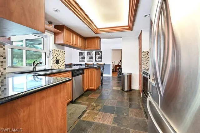 a kitchen with stainless steel appliances a sink and a refrigerator