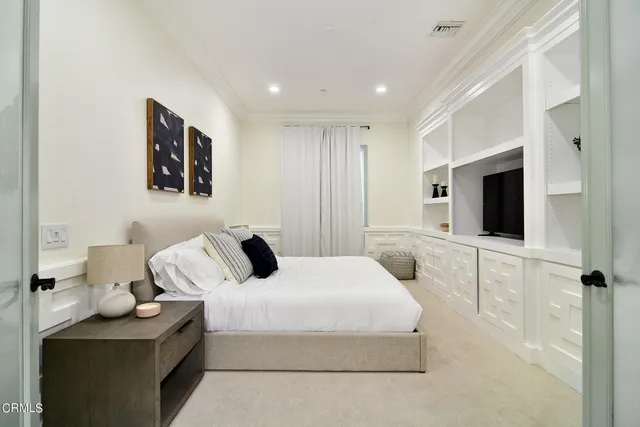 a bedroom with a bed and a flat screen tv