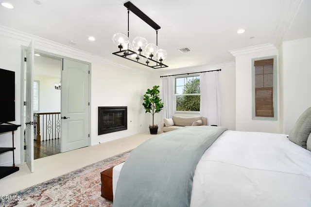 a bedroom with a large bed and a chandelier