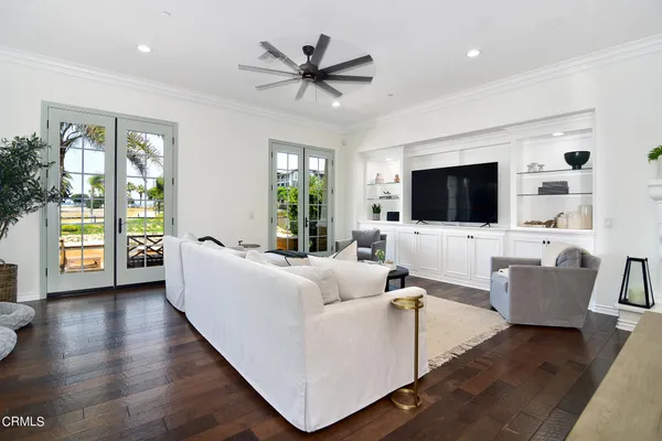 a living room with couches a flat screen tv and a large window