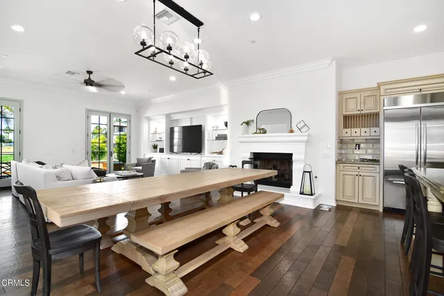 a large kitchen with a table chairs refrigerator and a fireplace