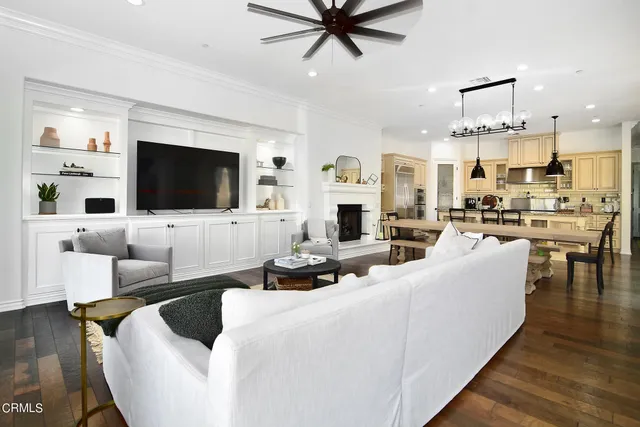 a living room with furniture kitchen view and a flat screen tv