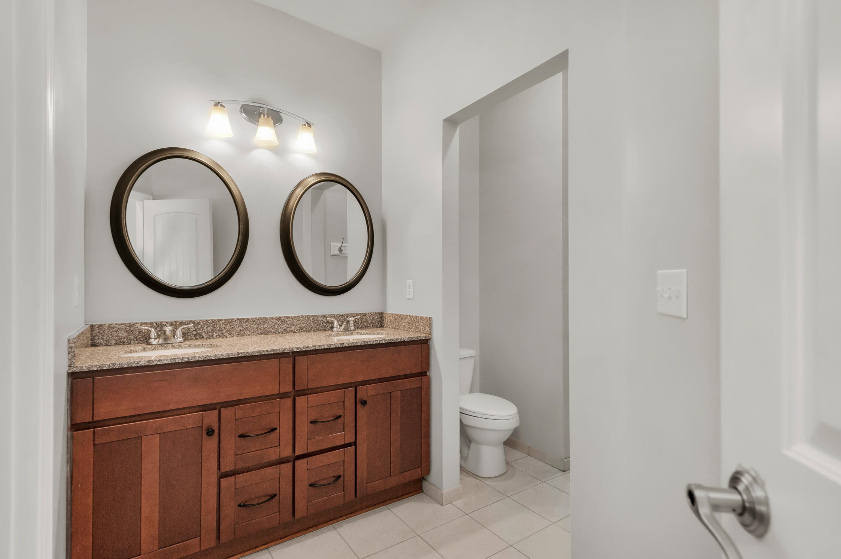 4586 Hermosa Road Crestview, FL 32539 - Photo 17 of 26 a bathroom with a toilet a double vanity and a two mirror