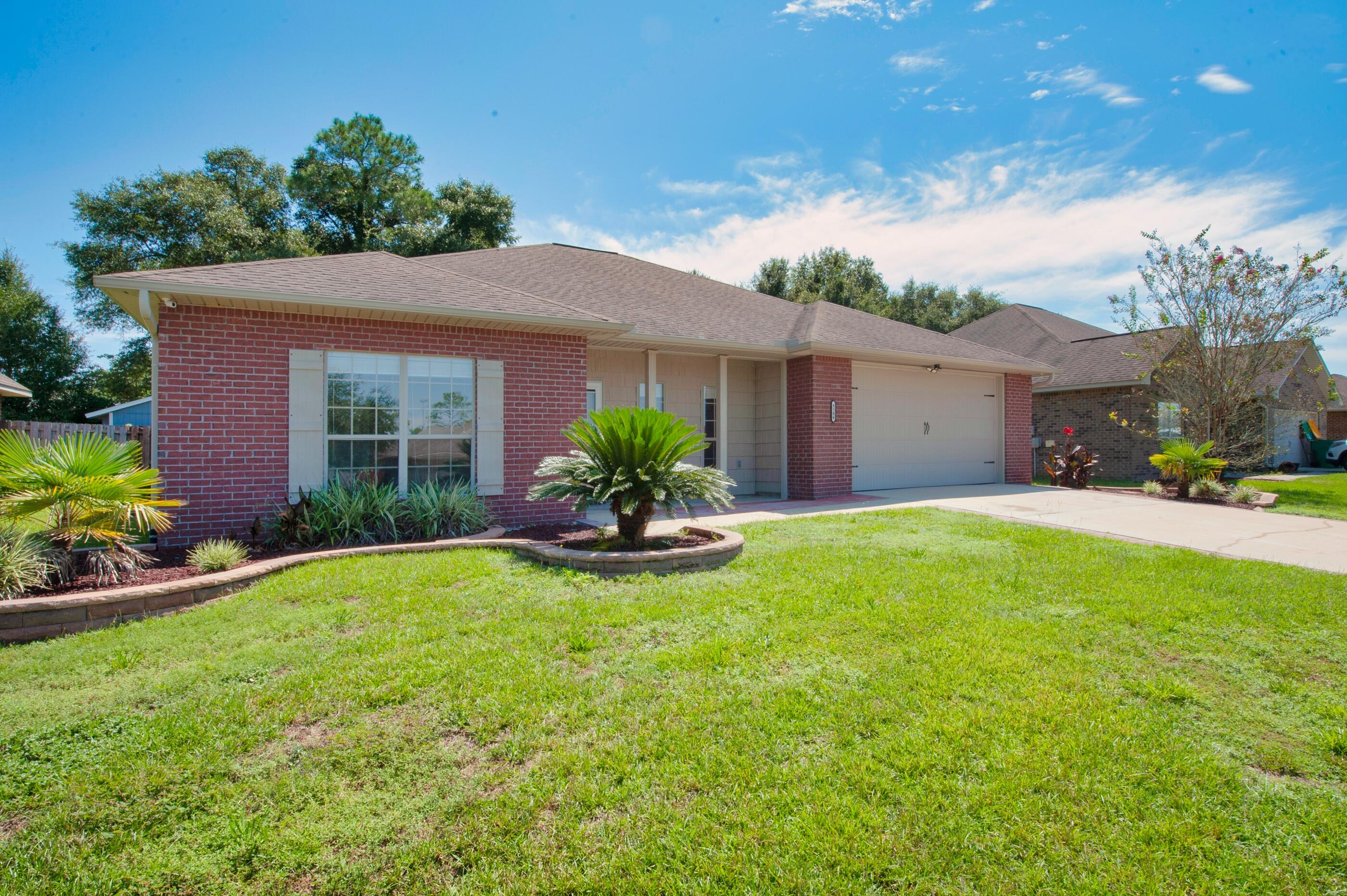 4586 Hermosa Road Crestview, FL 32539 - Photo 2 of 26 a view of a house with a yard and potted plants