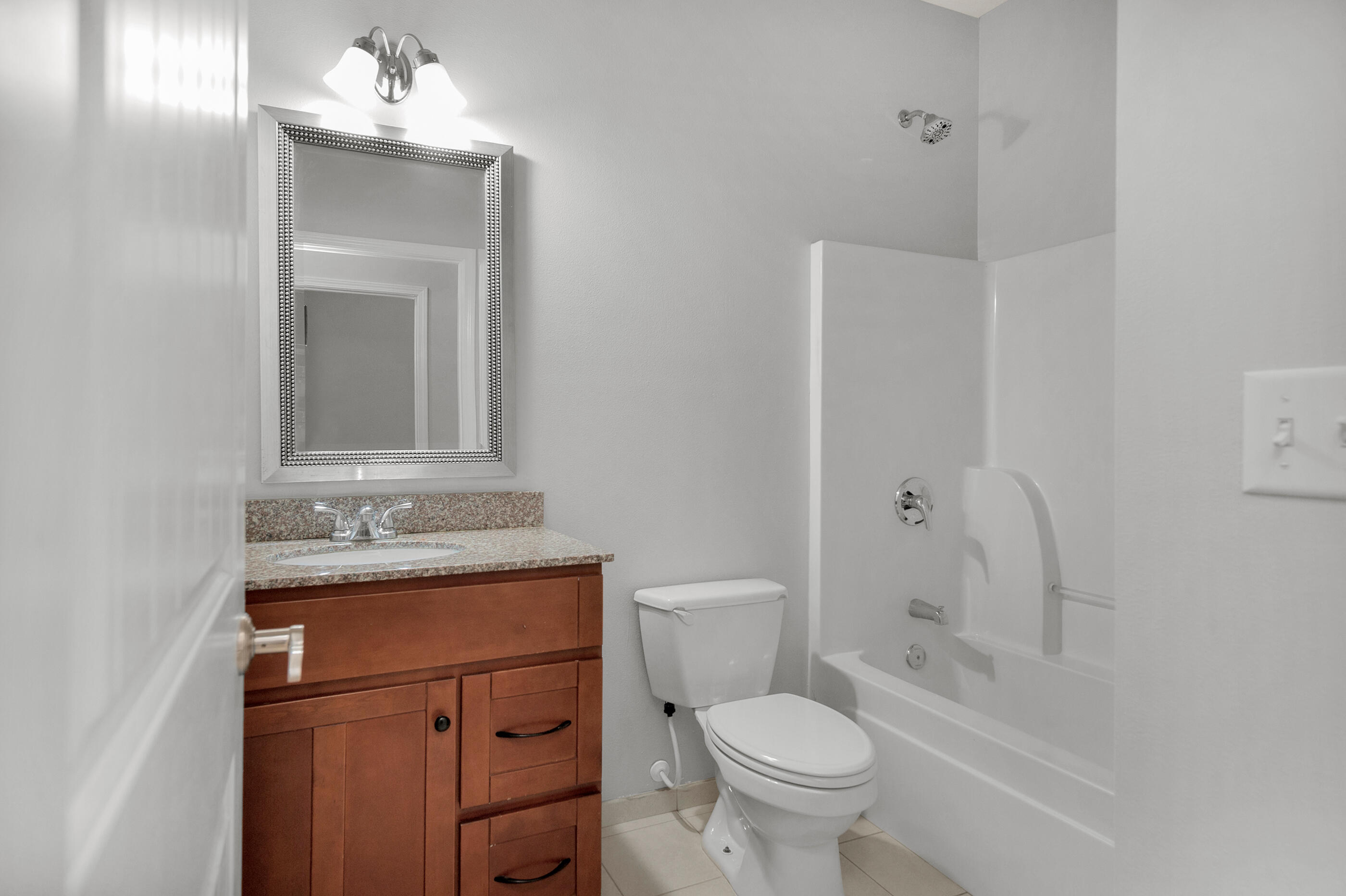 4586 Hermosa Road Crestview, FL 32539 - Photo 23 of 26 a bathroom with a granite countertop toilet sink and mirror