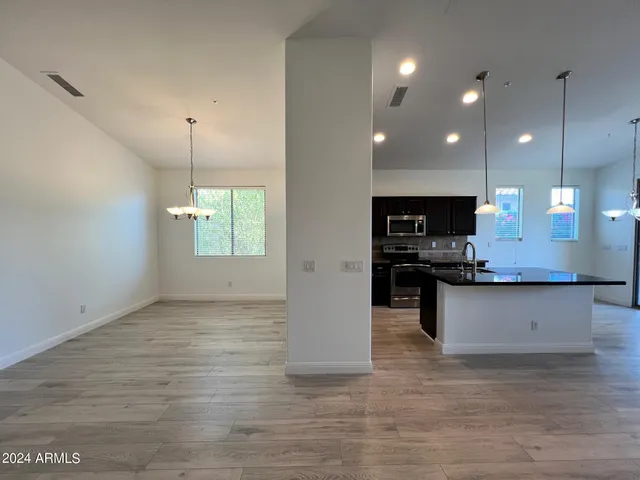 a view of a room with wooden floor and a chandelier