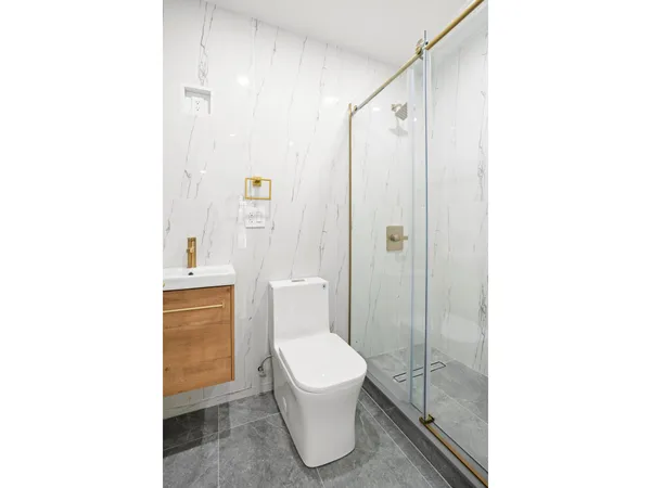 a bathroom with a toilet a sink and shower