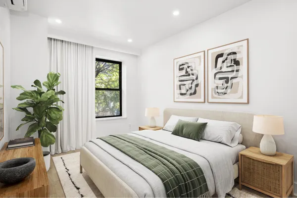 a bedroom with a large bed and a potted plant