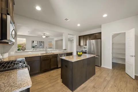 a kitchen with stainless steel appliances granite countertop a sink stove and refrigerator