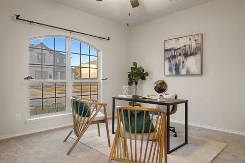 a view of a workspace with furniture and a window